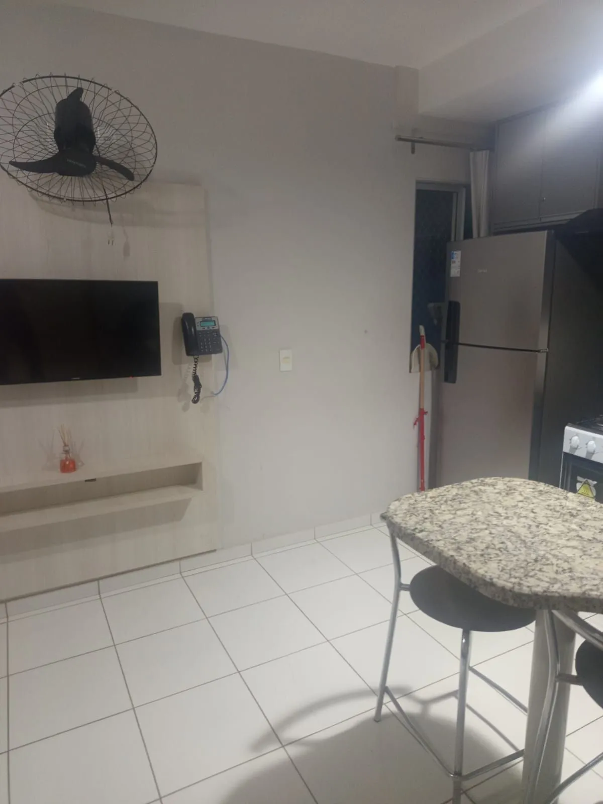 Ambiente do apartamento com TV na parede e geladeira