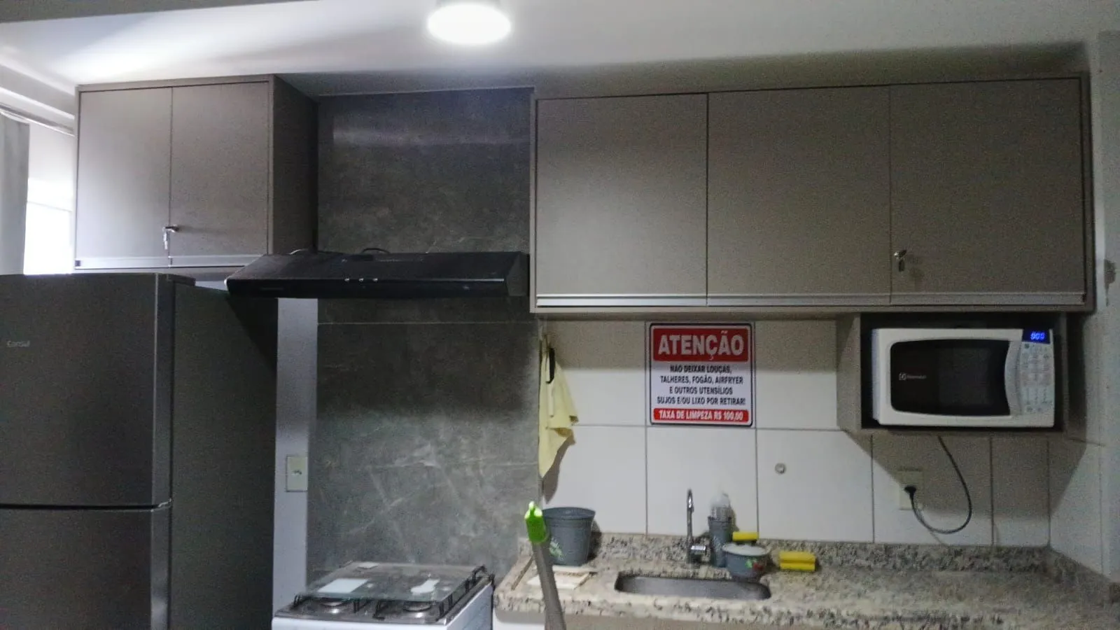 Cozinha com bancada de granito, armários e micro-ondas