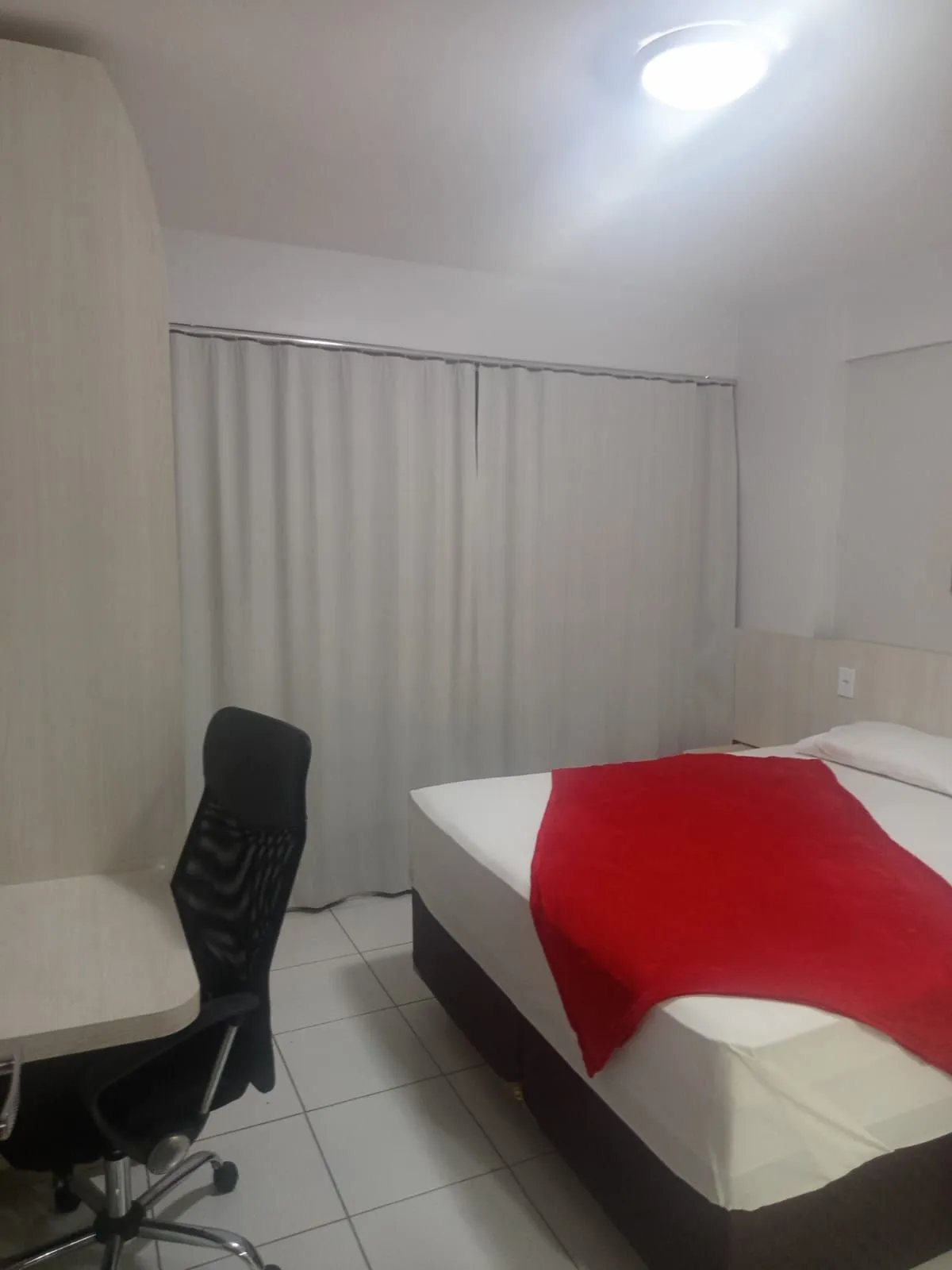 Quarto com cama de casal e cadeira