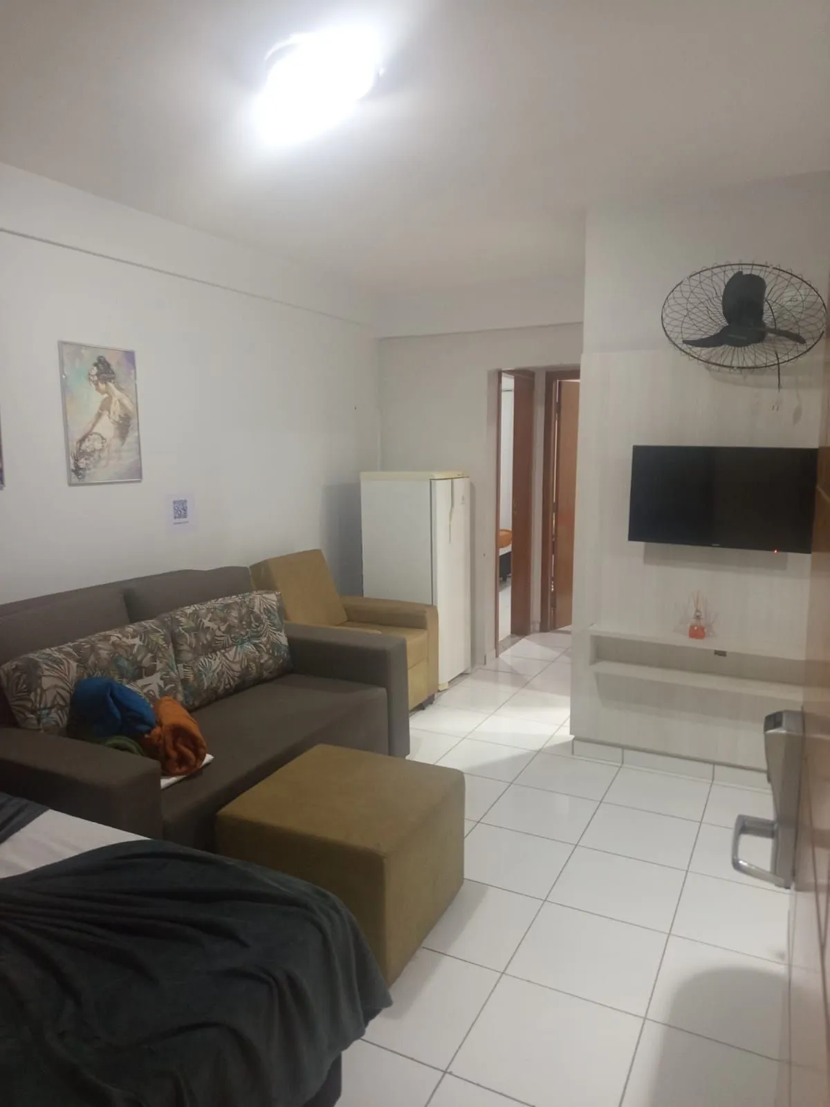 Sala de estar do apartamento com sofá, poltrona e TV